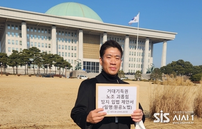 우해승 원공노 위원장이 서울시 영등포구 국회 본회의장 앞에서 원공노법 제안서를 들고 기념사진을 찍고 있다. (자료 = 원주시청 공무원노조)