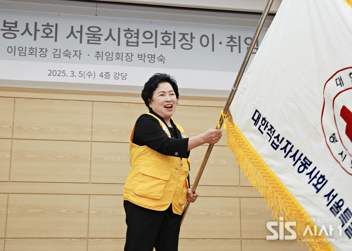 박명숙 대한적십자사봉사회 서울시협의회장이 취임 후 봉사회기를 흔들고 있다. (자료 = 대한적십자사 서울특별시지사.)