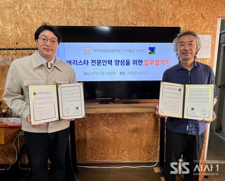 한국커피창업사관학교 최용국 대표(왼쪽)와 커피농장 산티아고 김철웅 대표가 업무협약 체결 후 기념 촬영을 하고 있다. / 한국커피창업사관학교