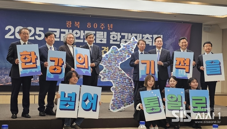 2025 코리안드림 한강대축제 조직위원회 관계자들이 한자 한자 적힌 '힌강의 기적을 넘어 통일로'라는 문구가 적힌 피켓을 들고 있다.(사진 =윤여진 기자) 2025.06.13/시사1