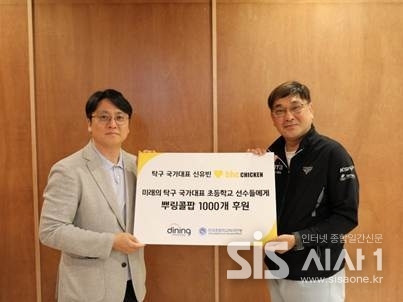  ‘뿌링콜팝 1,000개' 후원 전달식에서 박원철 다이닝브랜즈그룹 홍보담당 이사(왼쪽)와 서민성 한국초등학교탁구연맹 실무부회장이 기념촬영을 하고 있다. (자료 = 다이닝브랜즈그룹)