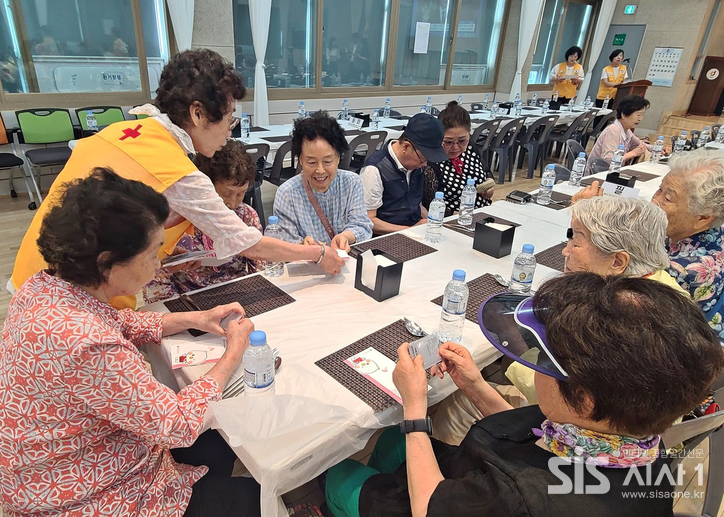 대한적십자사 서울지사 중구적십자봉사회 어르신 경로 효잔치에서 치매예방 홍보 리플릿을 전달하고 있다. (자료 = 대한적십자사 서울지사)