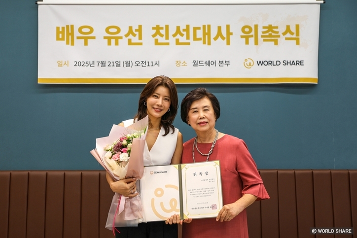 유선 친선대사와 월드쉐어 최순자 이사장이 위촉장을 들고 함께 웃고 있다. / 월드쉐어