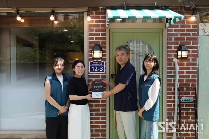 서울 성북구 '히포크라테스 스프'에서 열린 '청춘의 밥' 프로젝트 50호점 현판식에서 김경숙 대상주식회사 ESG경영실장(좌측부터 두 번째)과 김혁 '히포크라테스 스프' 대표(좌측부터 세 번째)가 대상 대학생봉사단원들과 기념사진을 촬영하고 있다. (자료 = 대상그룹)