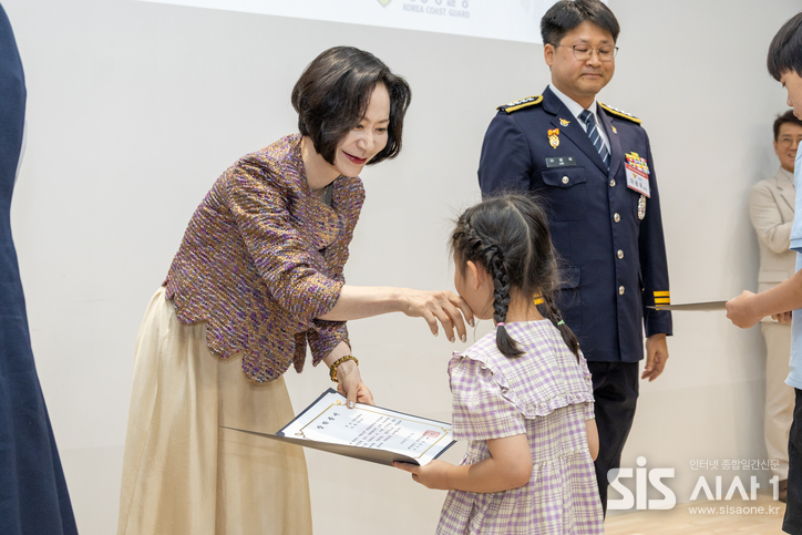 롯데장학재단 장혜선 이사장이 장학생에게 장학증서를 수여하며 인사를 나누고 있다. (자료 = 롯데장학재단)