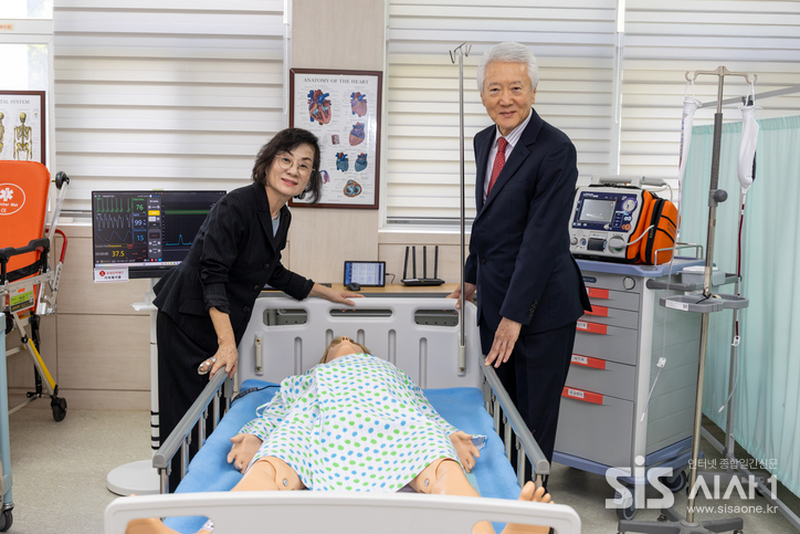 황명희 롯데장학재단 이사(왼쪽)와 조돈영 롯데삼동복지재단 이사가 롯데장학재단에서 기증한 기자재 앞에서 기념촬영을 하고 있다.