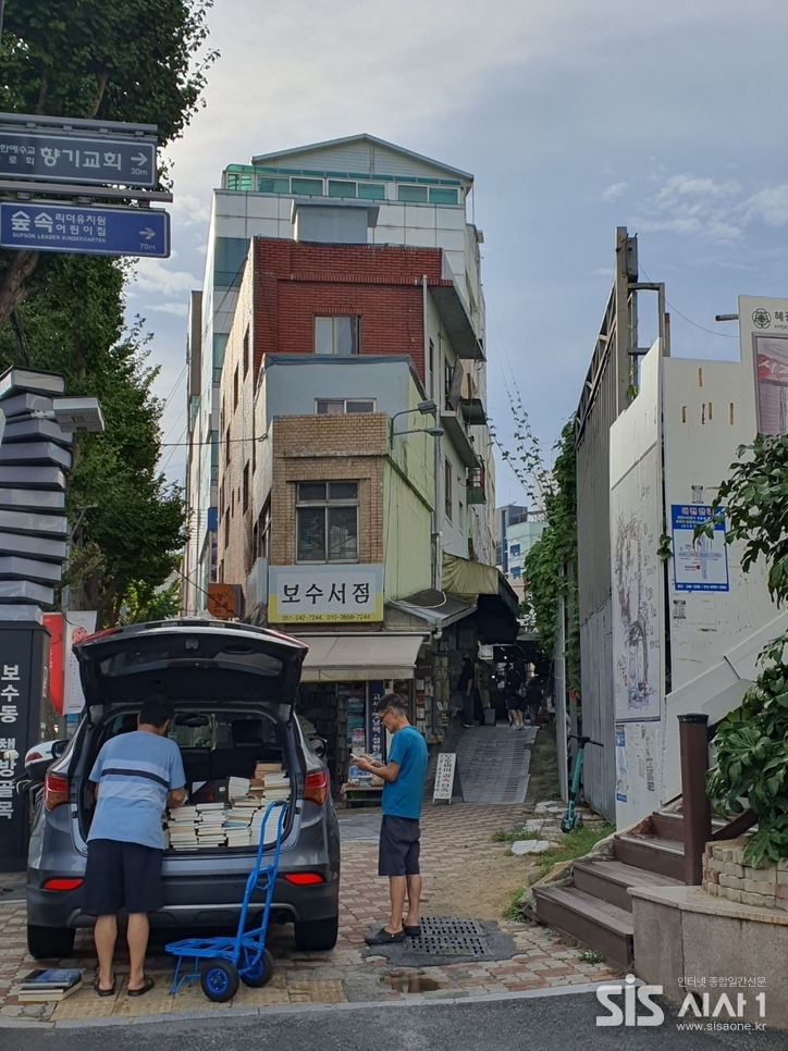 보수동 책방골목 입구에서 상인이 헌책을 정리하고 있다.(사진=노은정 기자). 2025. 9.월/ 시사1
